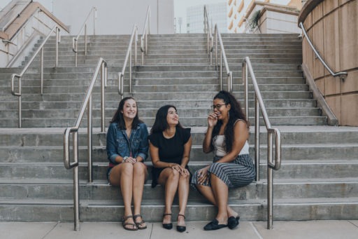 three women smiling on stairs